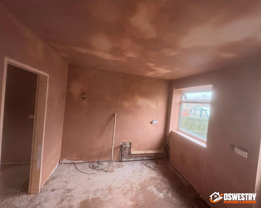 Reception room walls and ceiling freshly bonded and skimmed in pink plaster by Oswestry Plastering & Rendering, smooth even finish ready for decoration